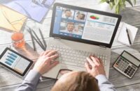 A person sitting at a laptop looking at information about a virtual event.